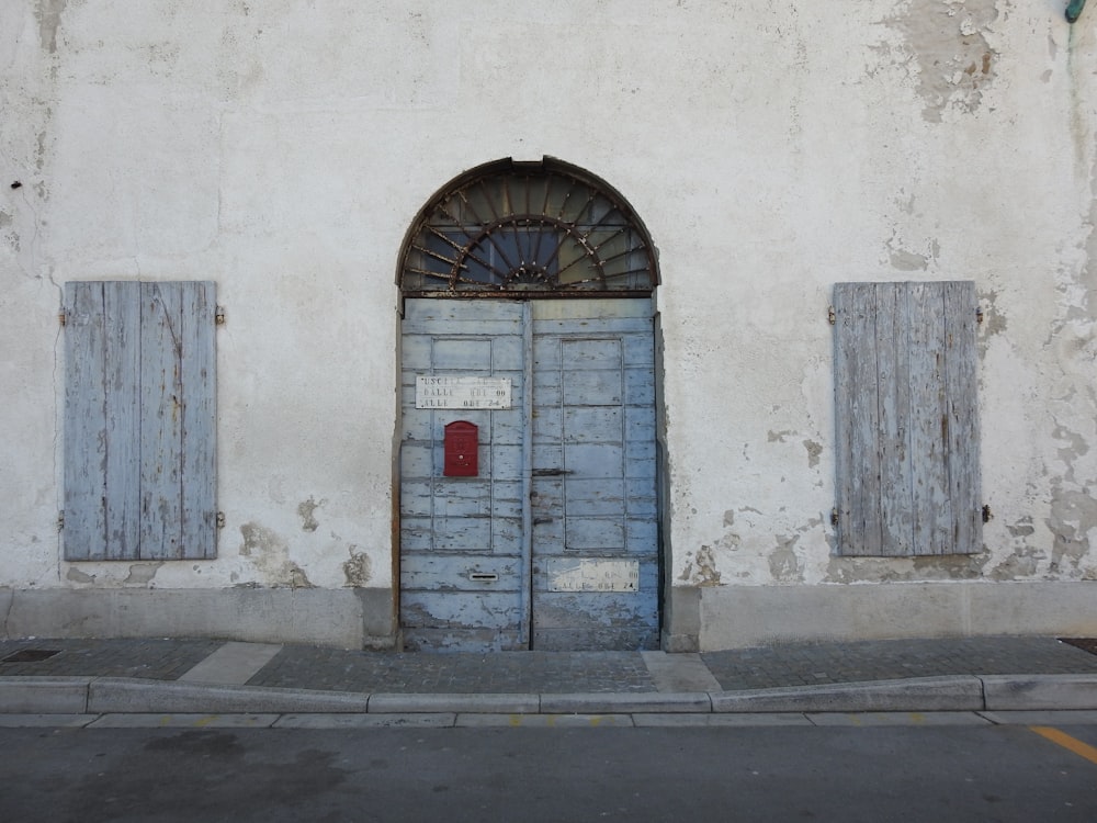 puerta de madera azul entre las puertas de las ventanas