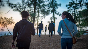 Sunset over a forest trail with hikers walking together