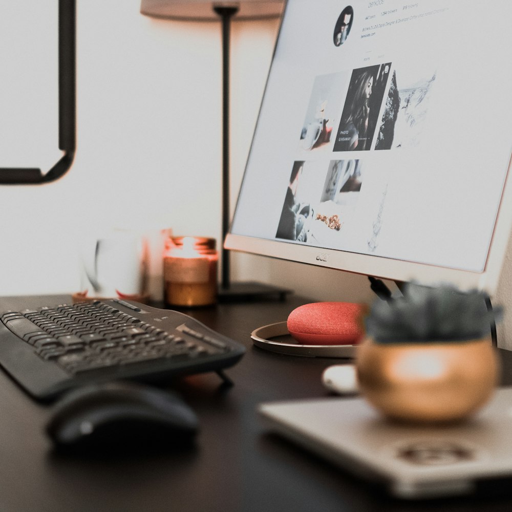 Monitor de computadora de pantalla plana blanca en la parte superior de la mesa de madera negra