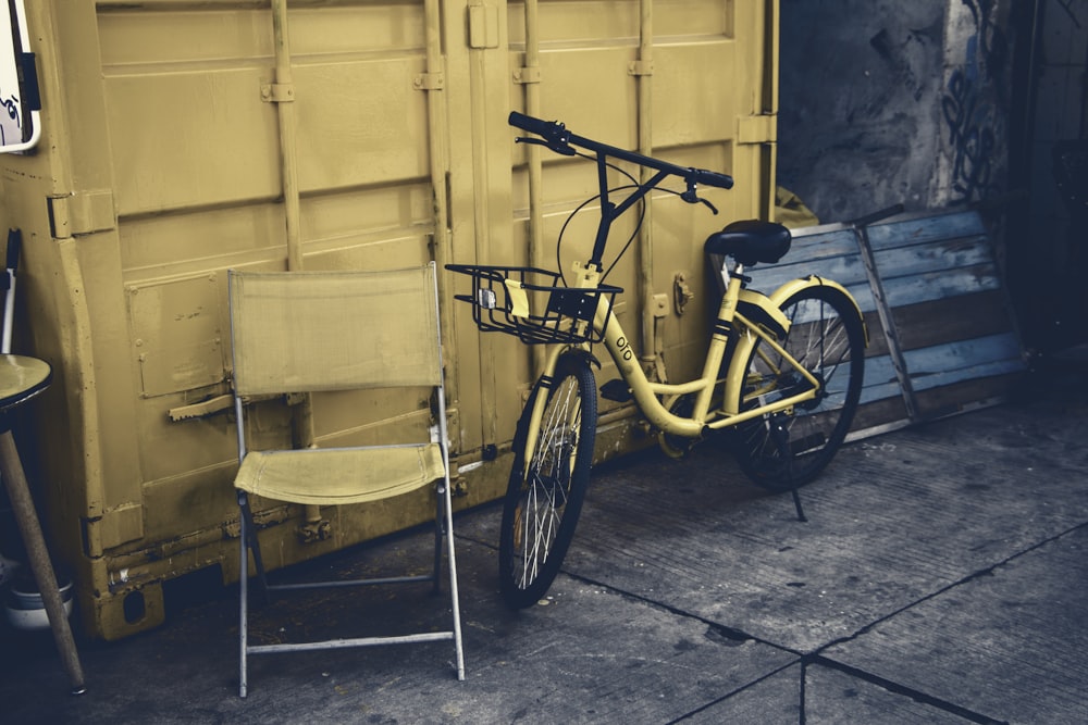 Bicicleta urbana amarilla apoyada en la pared