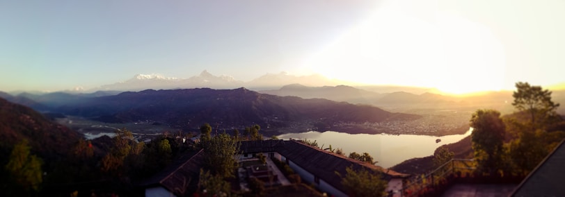 A panoramic view of a serene mountain lake at sunset.