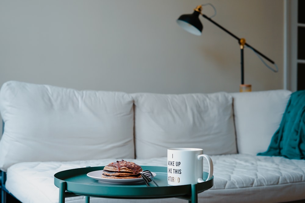 pancake and mug on top of end table near sofa