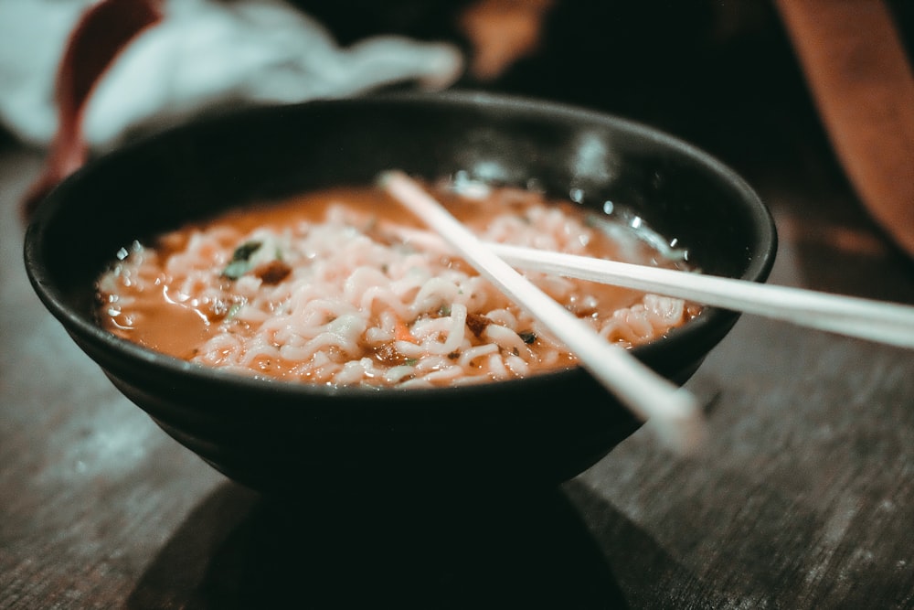 a bowl of food with chopsticks in it