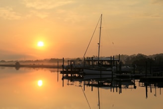 A peaceful sunrise over the ocean with a silhouette of a liveaboard vessel.