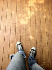 A pair of youthful, casual espadrilles resting on a sunlit wooden deck with soft natural tones.