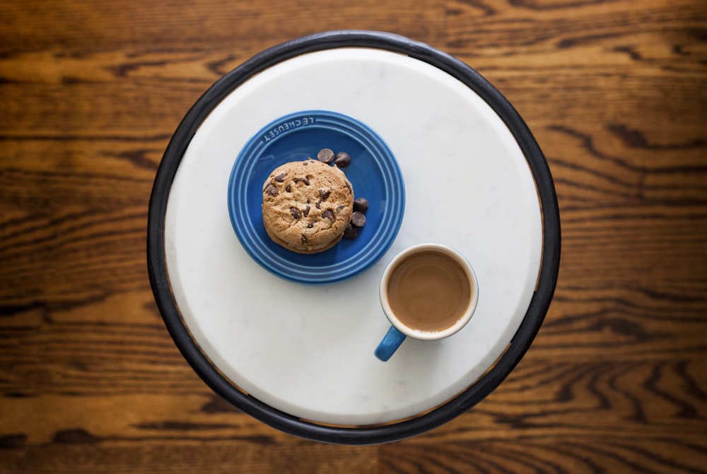 a plate with a cookie and a cup of coffee