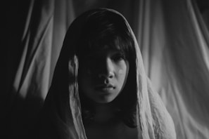 A striking portrait of Shadowsylph in a flowing black cloak, framed by twisted dark forest branches under a silver moon.