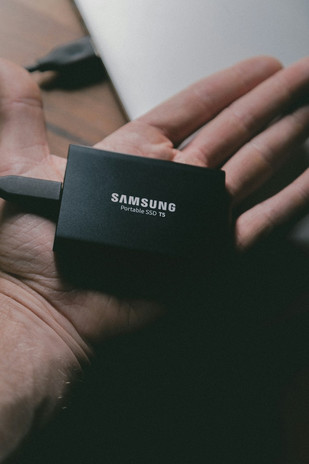 SSD portátil T5 de Samsung en la mano de una persona