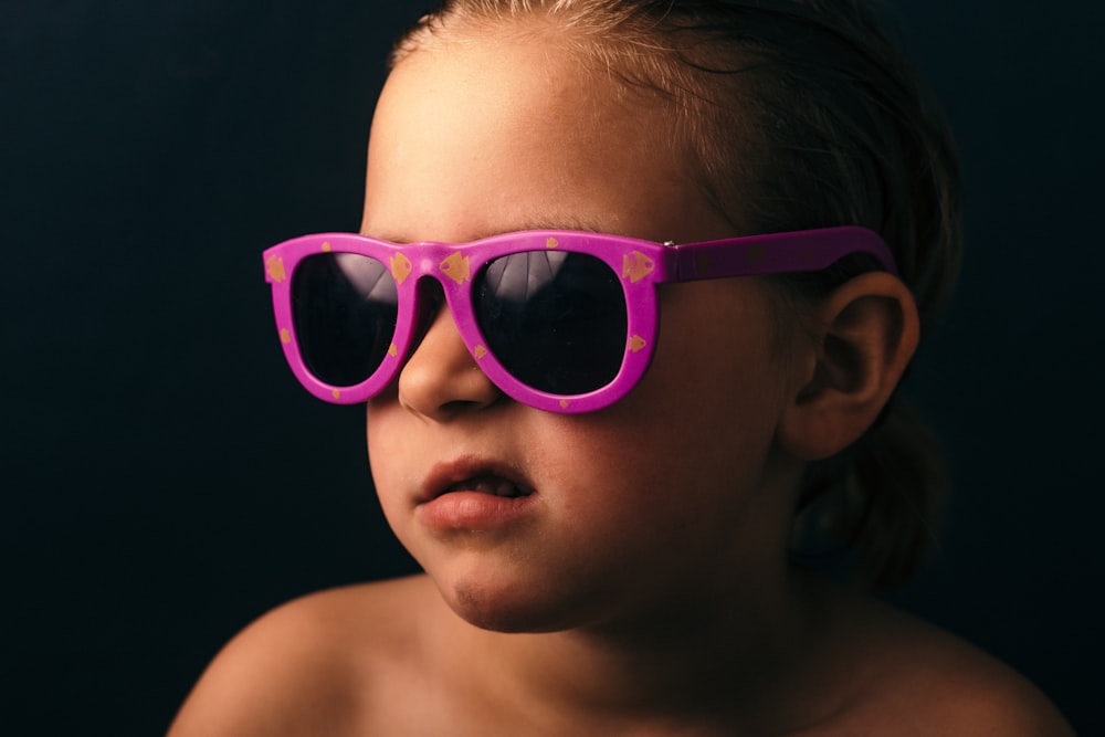 분홍색 액자 선글라스를 착용 한 소녀