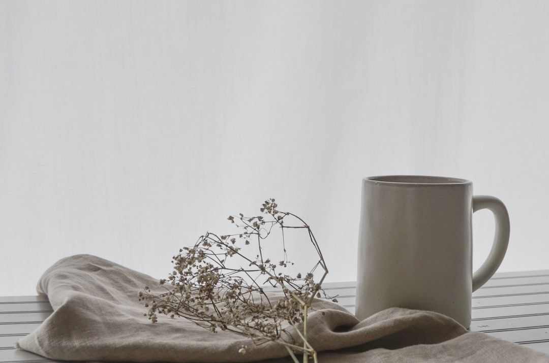 white ceramic mug on table,