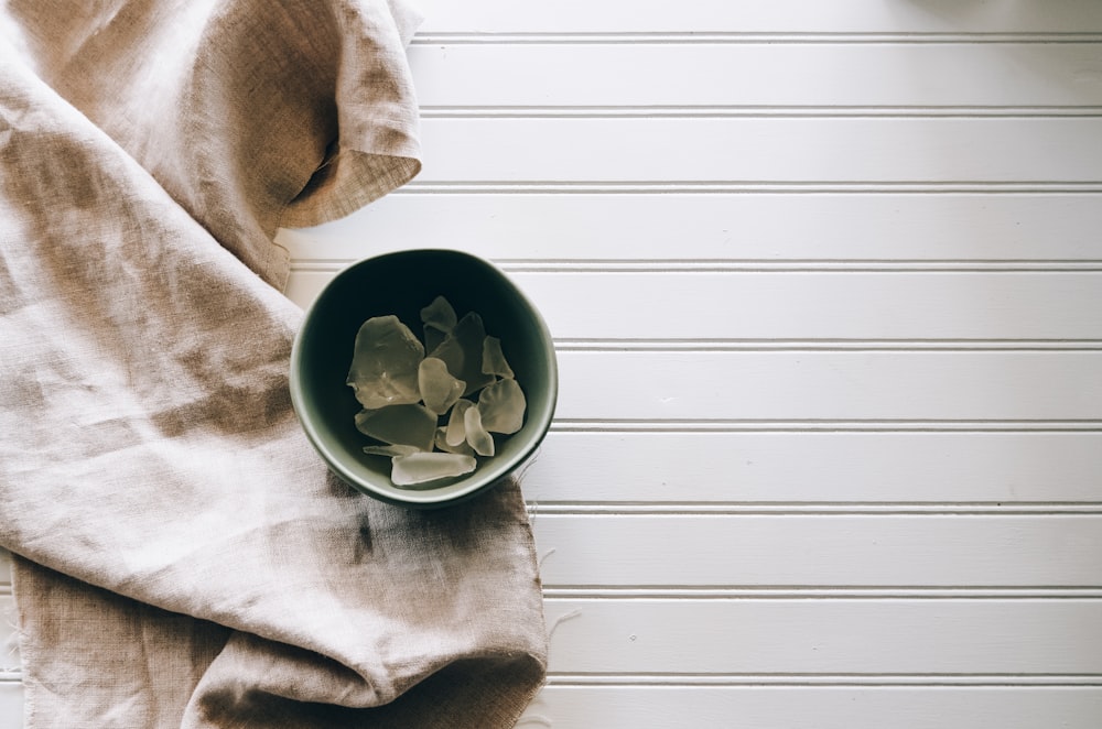 gray ceramic bowl beside gray textile