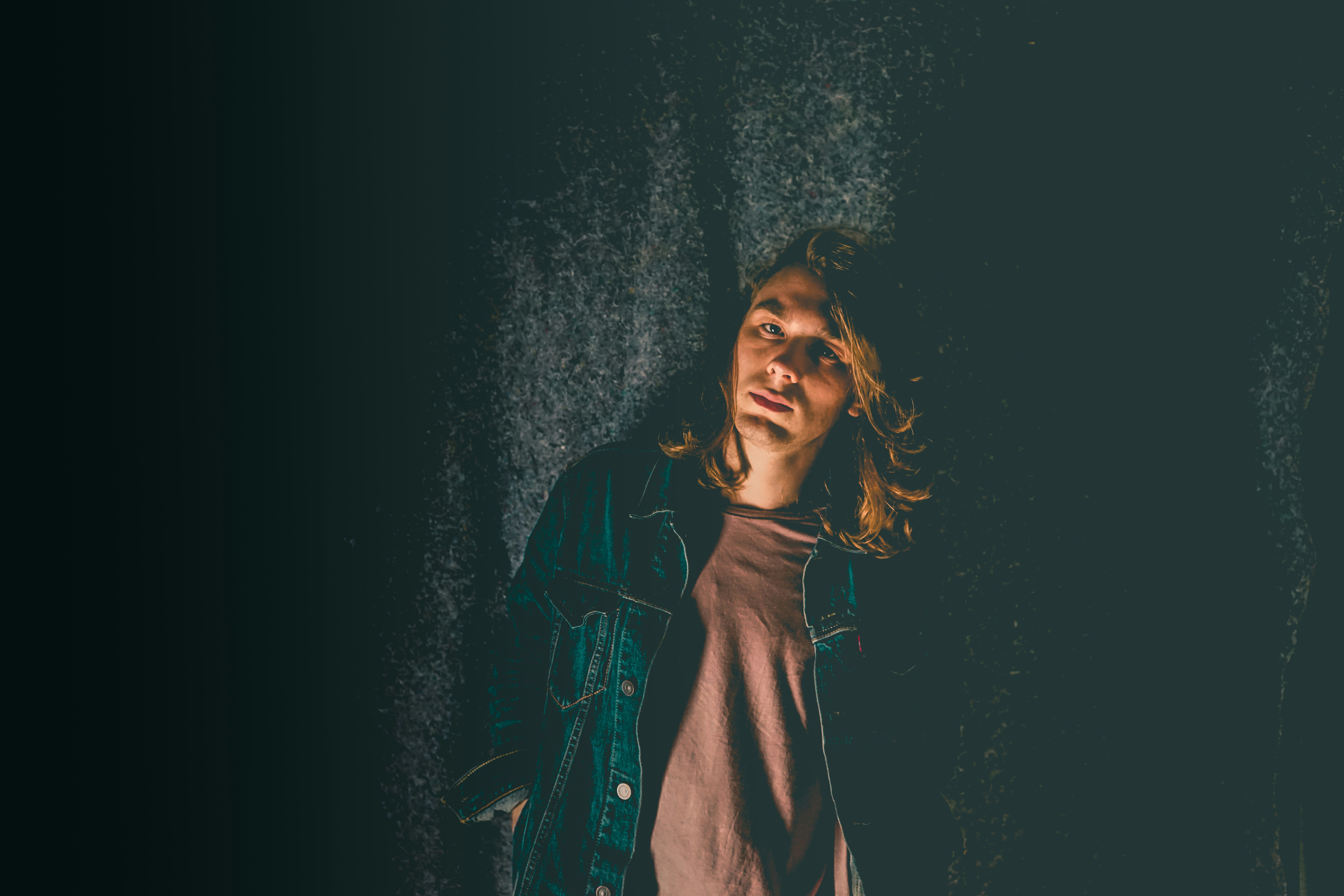 man standing beside black curtain