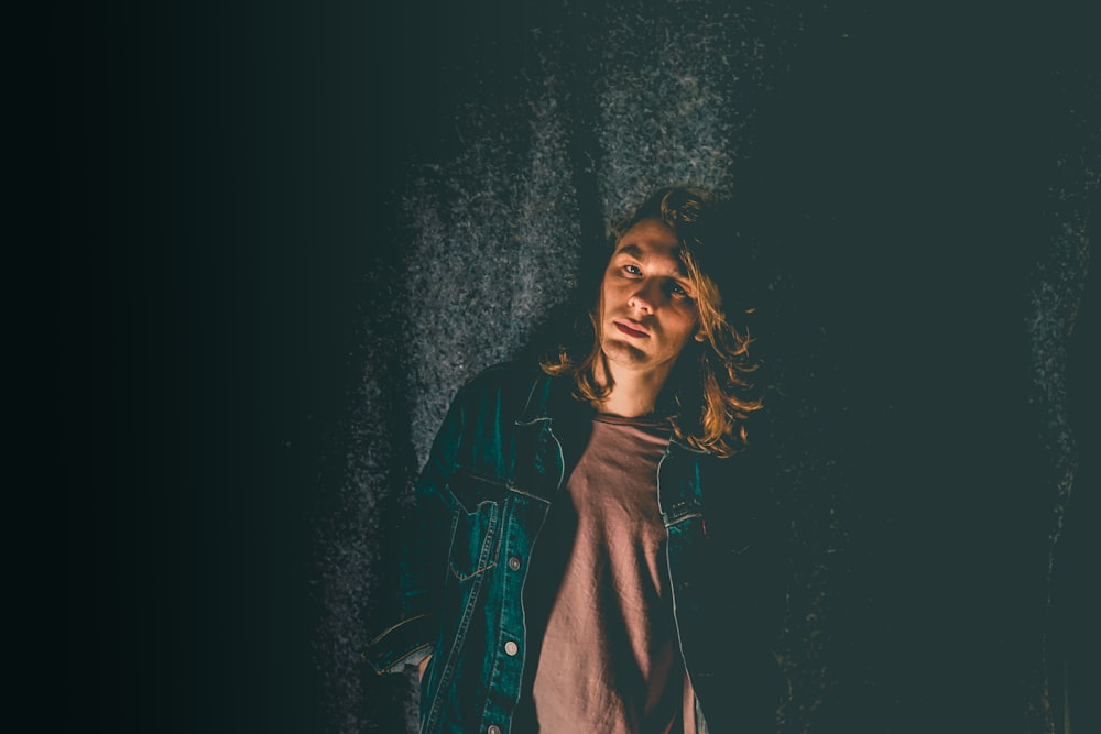 man standing beside black curtain