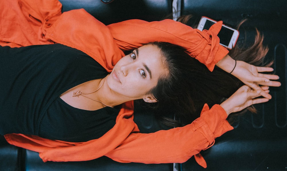 woman laying down on black leather couch