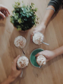 A family gathering around a rustic wooden table in Alcalá, sharing stories over fresh coffee.