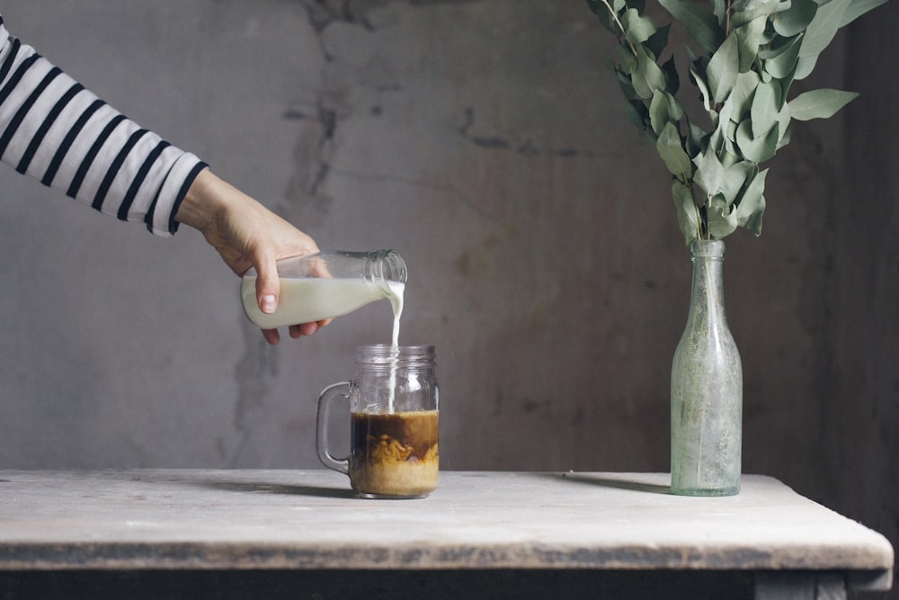 personne remplissant du lait sur verre