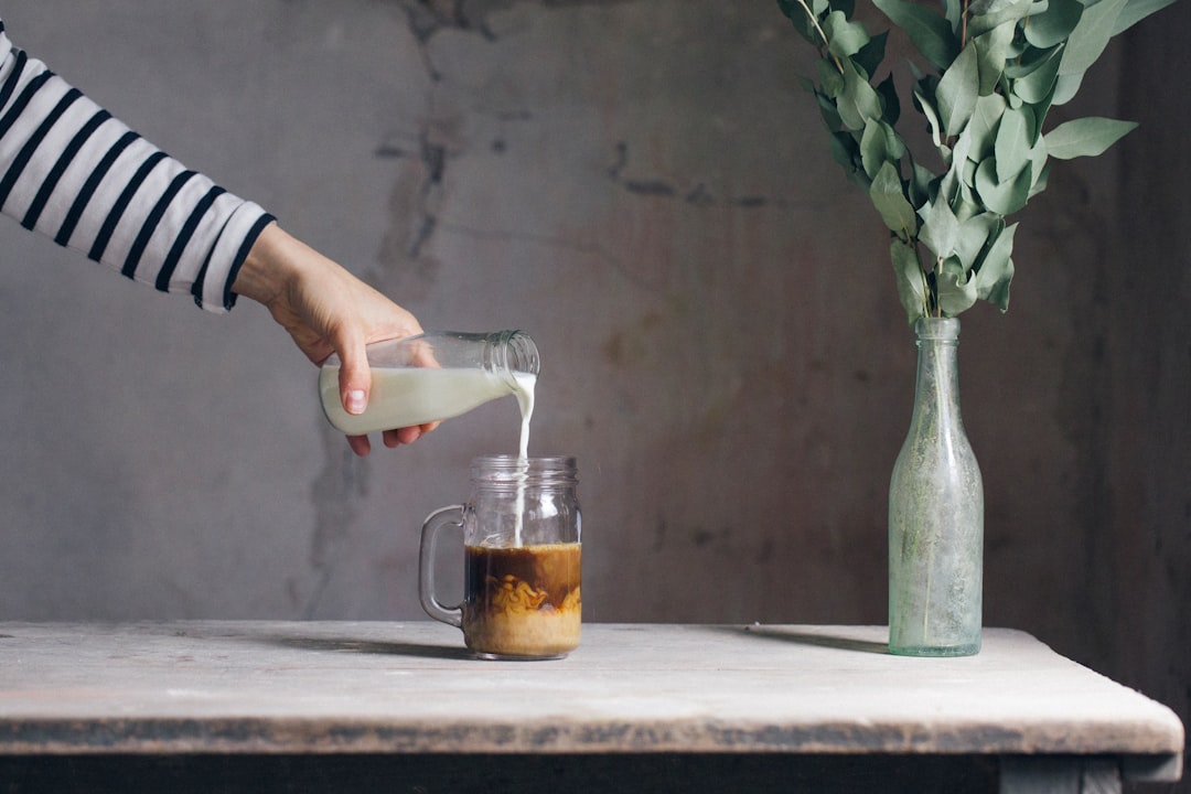 person filling milk on glass