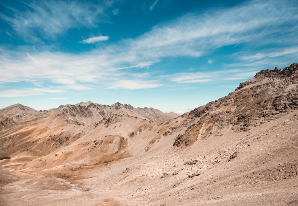 Berghügel unter weißem und blauem Himmel