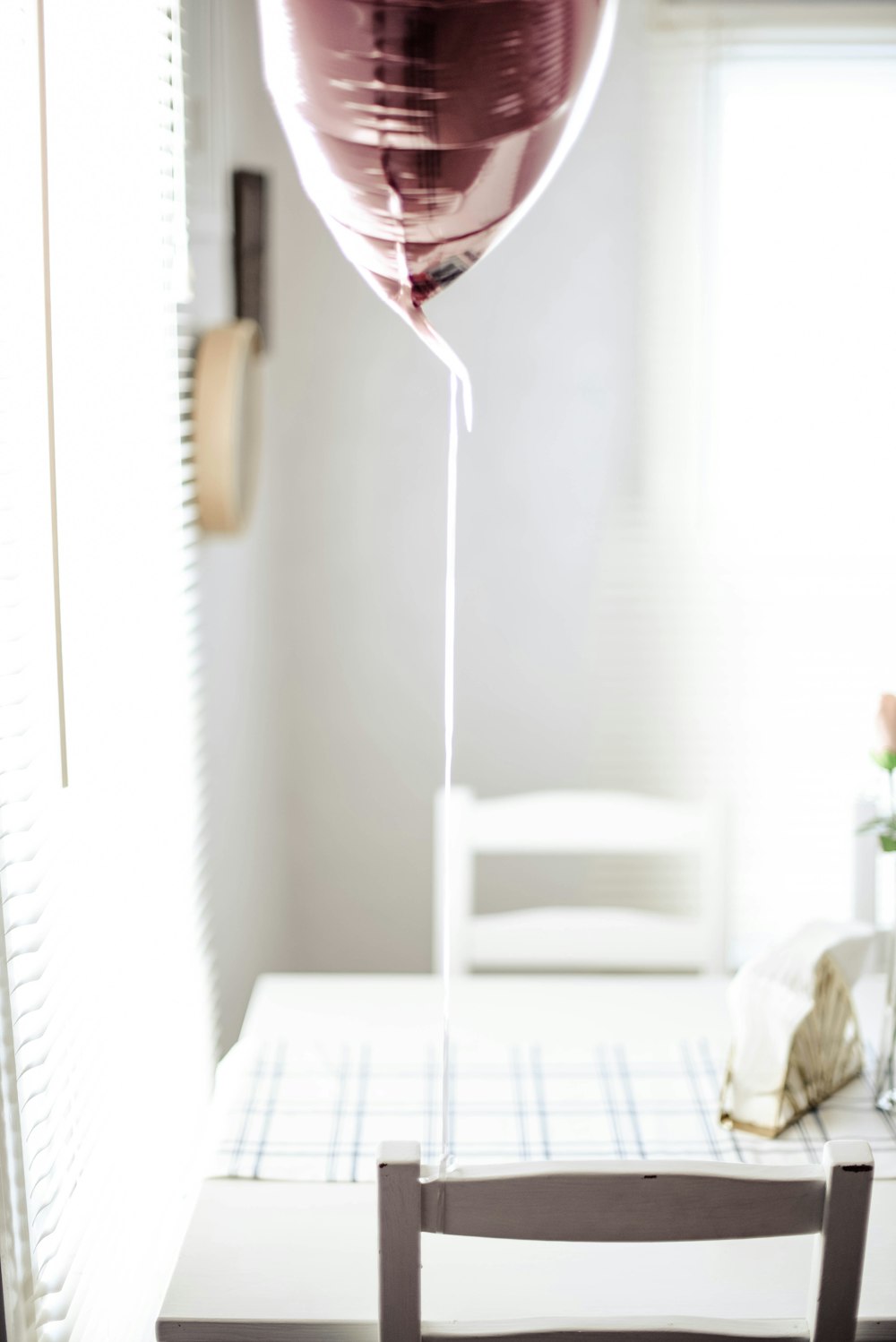 minimalist photography of balloon tied on chair