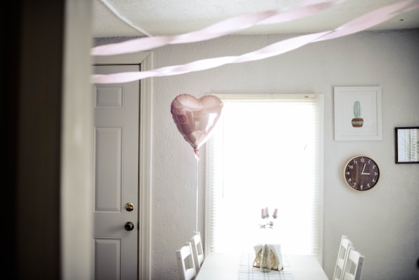 A cozy anniversary setting adorned with heart-shaped balloon arches and soft glowing lights.