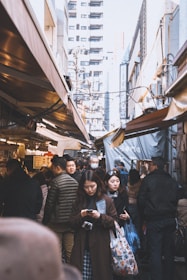 A small village market bustling with people using digital devices.