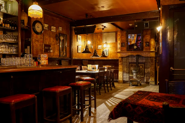 Cozy interior of a cocktail bar with warm lighting and wooden accents.