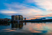 Close-up of a peaceful riverside hotel terrace overlooking calm water at sunset.
