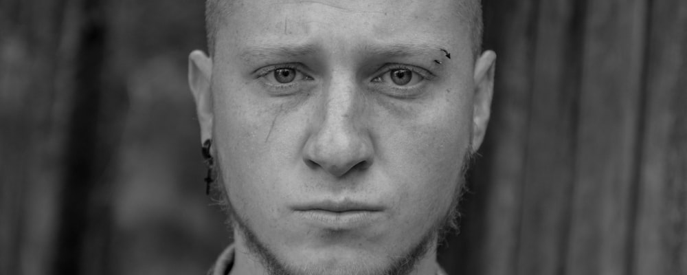 a black and white photo of a man with a shaved head