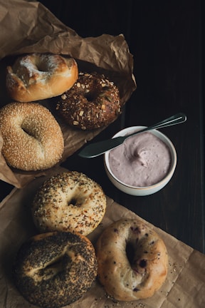 A variety of bagels arranged on a rustic wooden board.