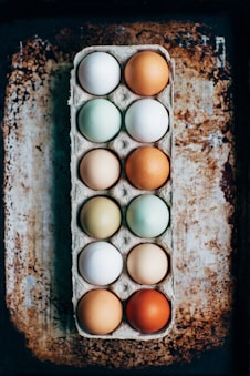 colourful eggs in a tray on a rustic table