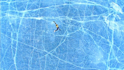 person falling on blue surface ice skates teams background