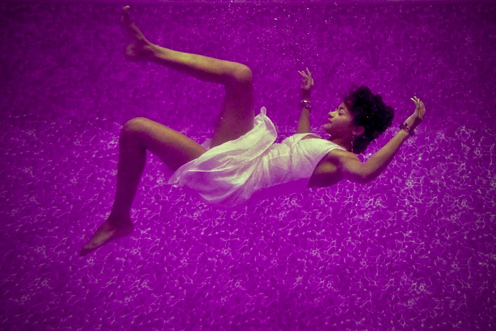 紫色の水面に落ちる女性