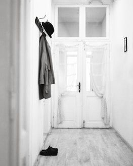 Charming hallway with hooks for coats, a mirror, and a small console table.