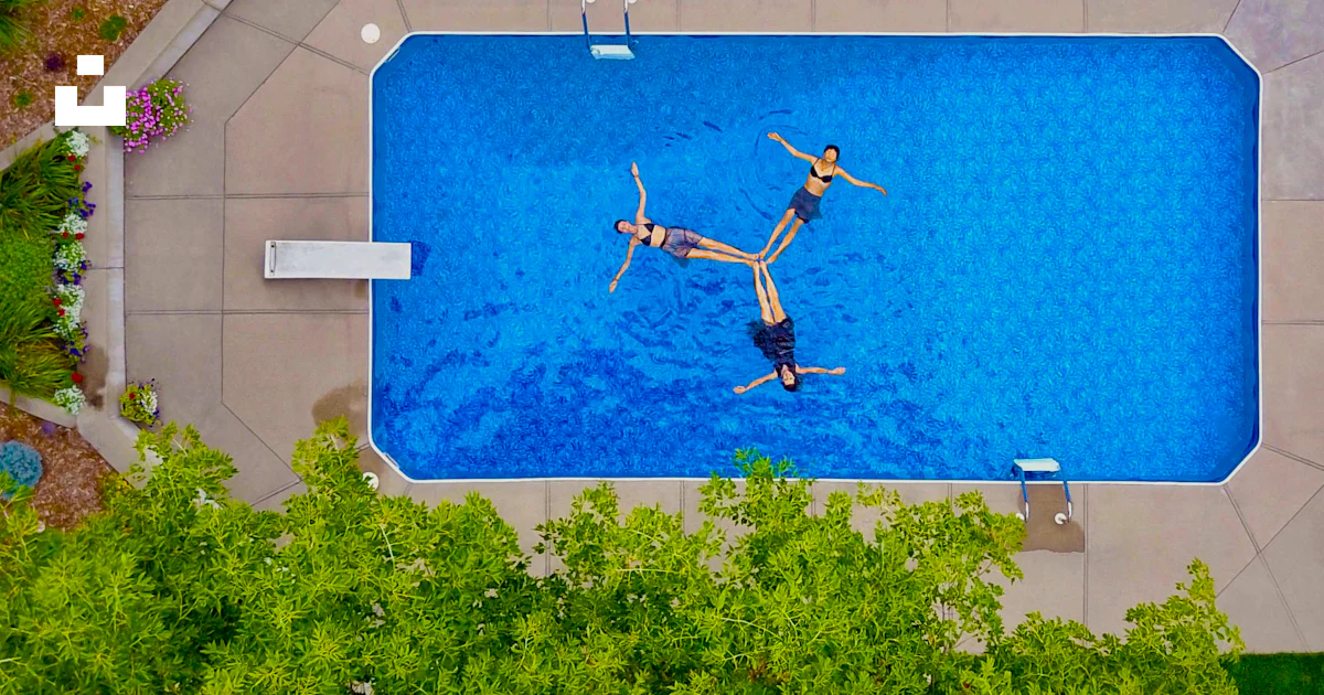Propeller Pool Aerial photography of three women floating on pool forming propeller ...