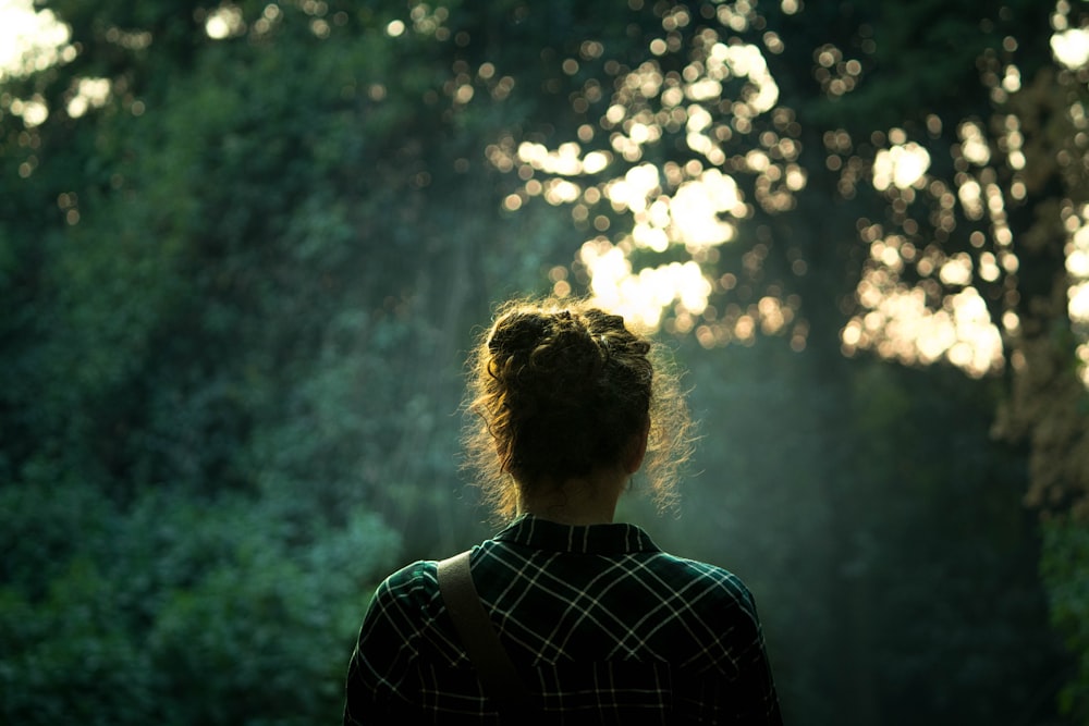 donna di fronte agli alberi