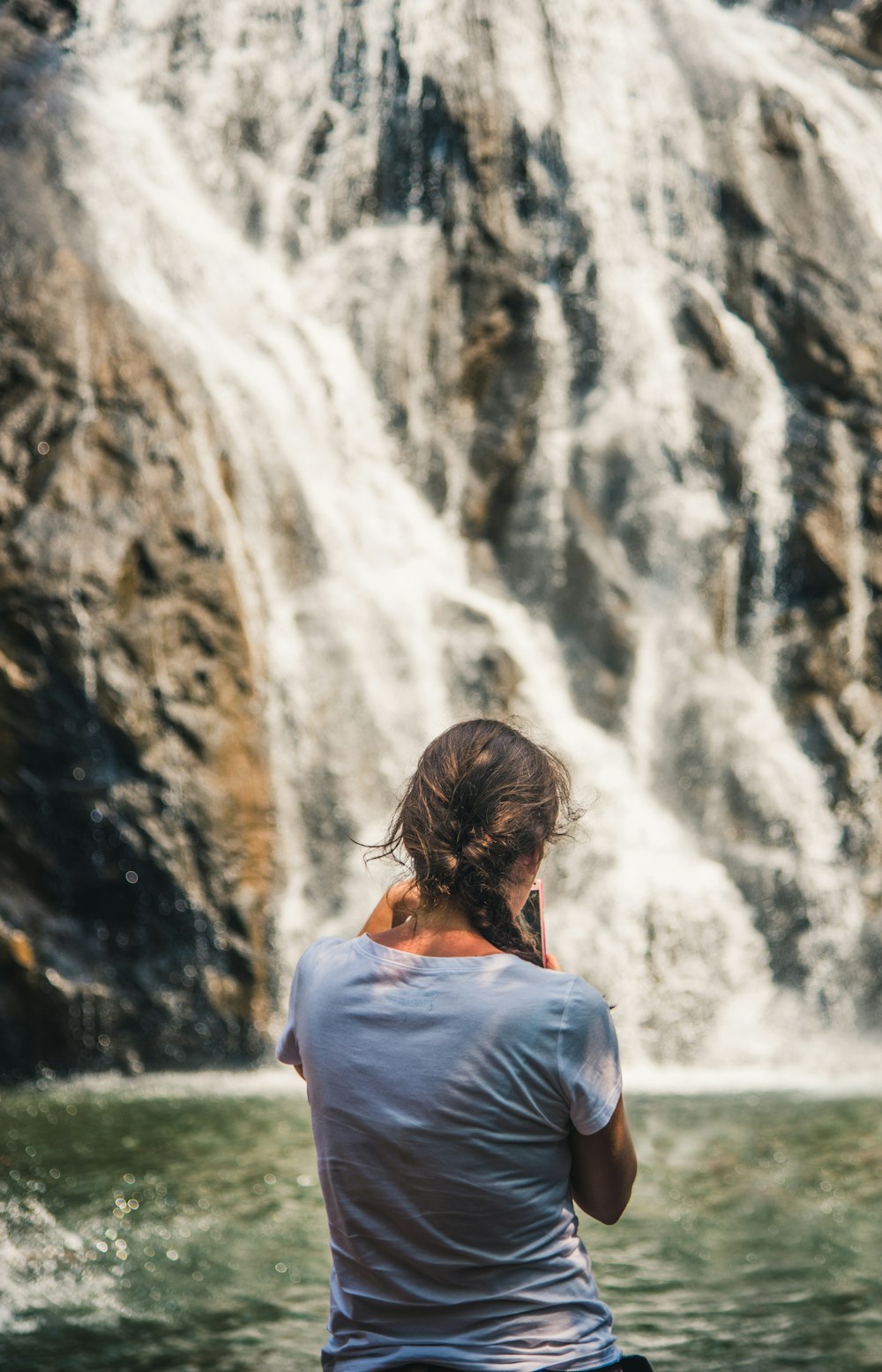 woman standing in front of waterfall