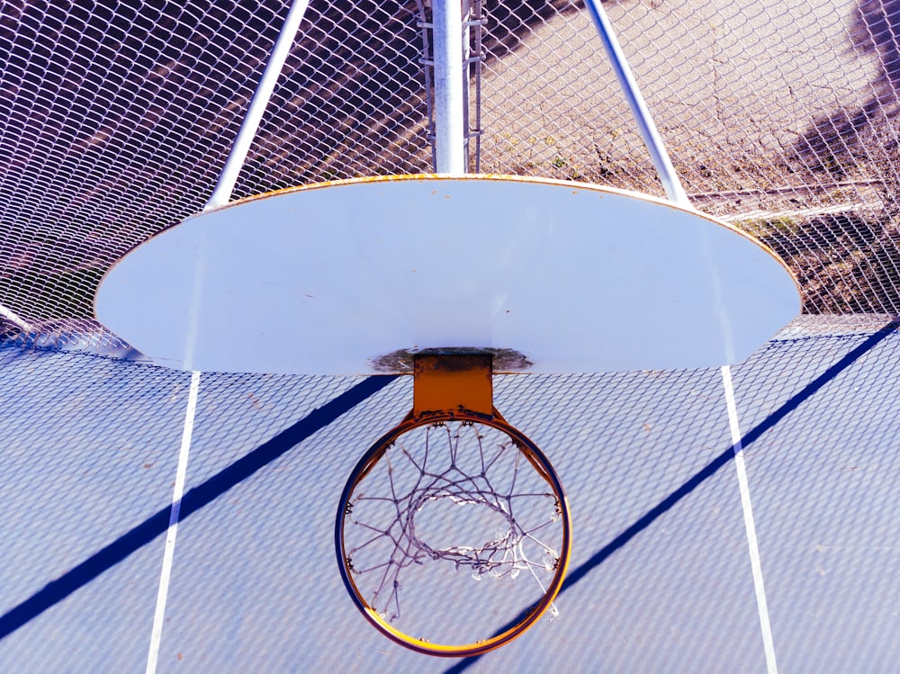aro de basquete branco e laranja durante o dia