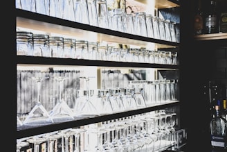 A collection of various glassware displayed on a shelf.