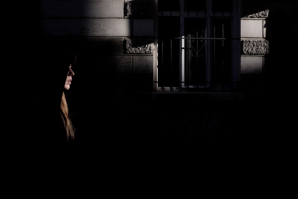 a woman walking down a dark street at night