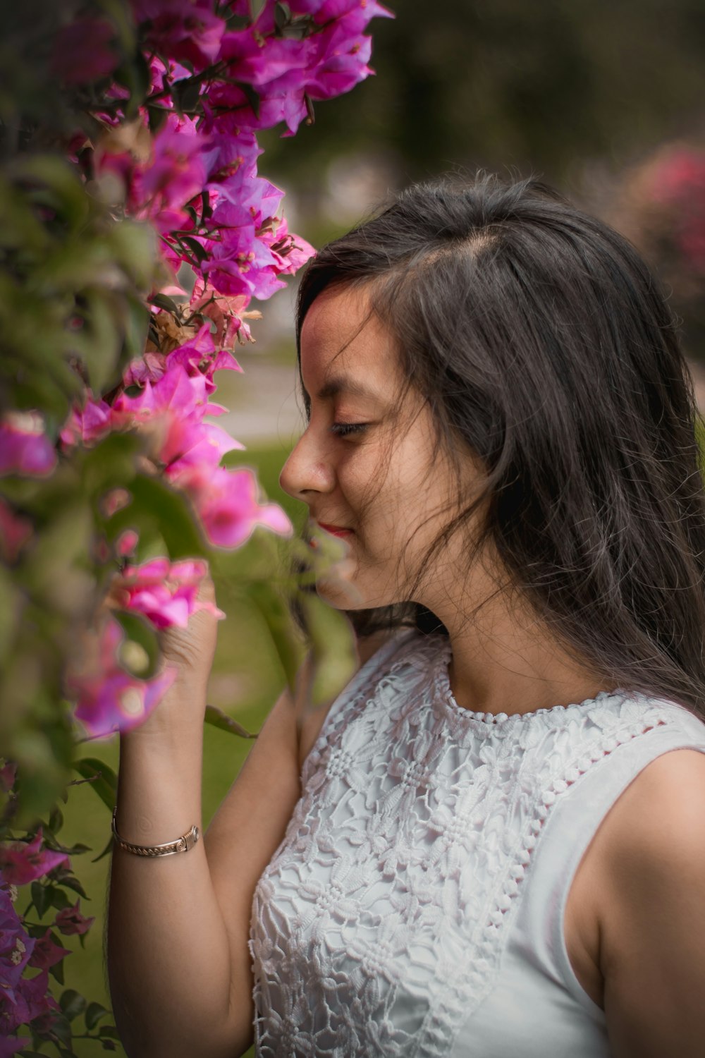 smiling woman smelling bougainvilleas in closeup shot