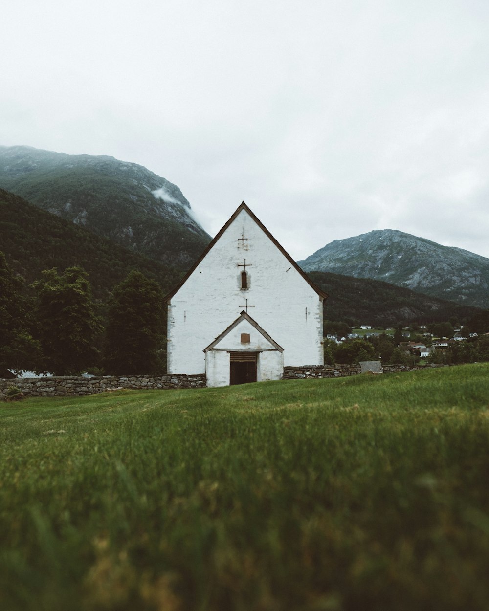 Église en béton blanc près des sommets des montagnes