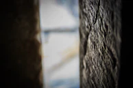 Close-up in grayscale of textured stone wall with soft gradient lighting.