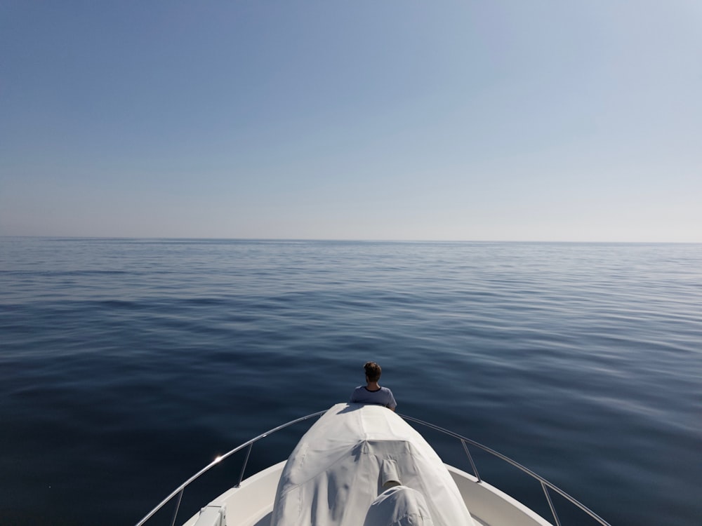 a person sitting on a boat in the middle of the ocean