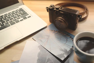 A vintage-inspired travel brochure alongside a modern laptop and coffee cup on a wooden desk.