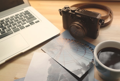 A warm, inviting photo of a camera and notebook on a black and yellow themed desk