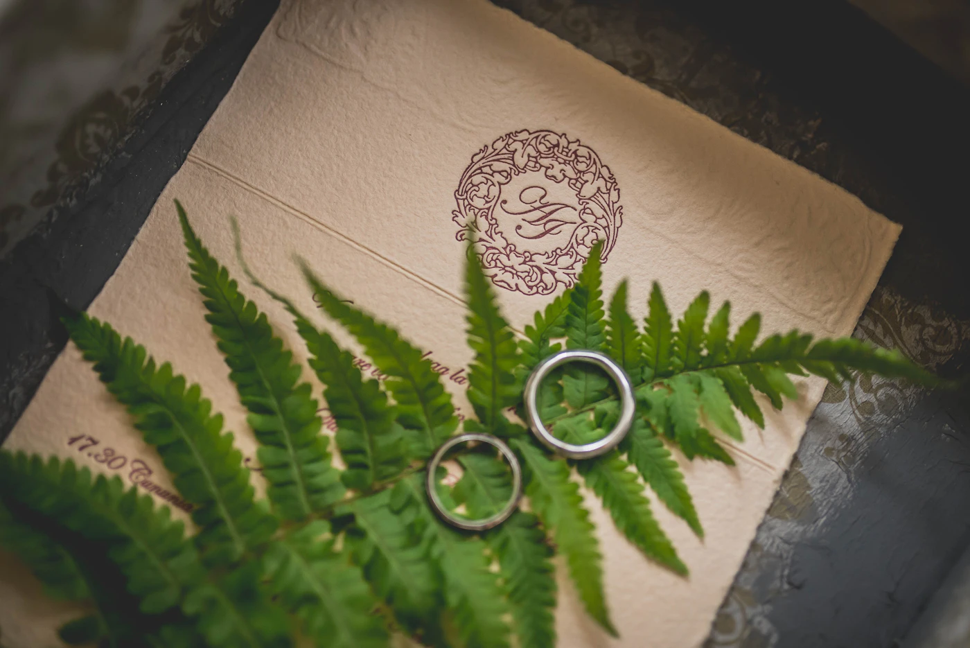 Two silver wedding rings arranged on a wedding invitation