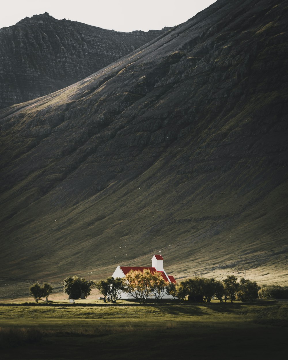 Casa cercada por árvores perto da montanha