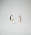 Stacked thin rings in mixed metals on a hand against a neutral background.