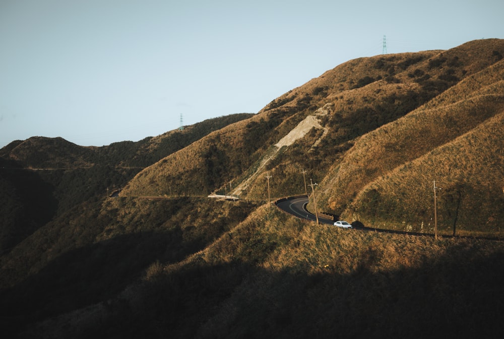 white vehicle on road near mountain at daytime