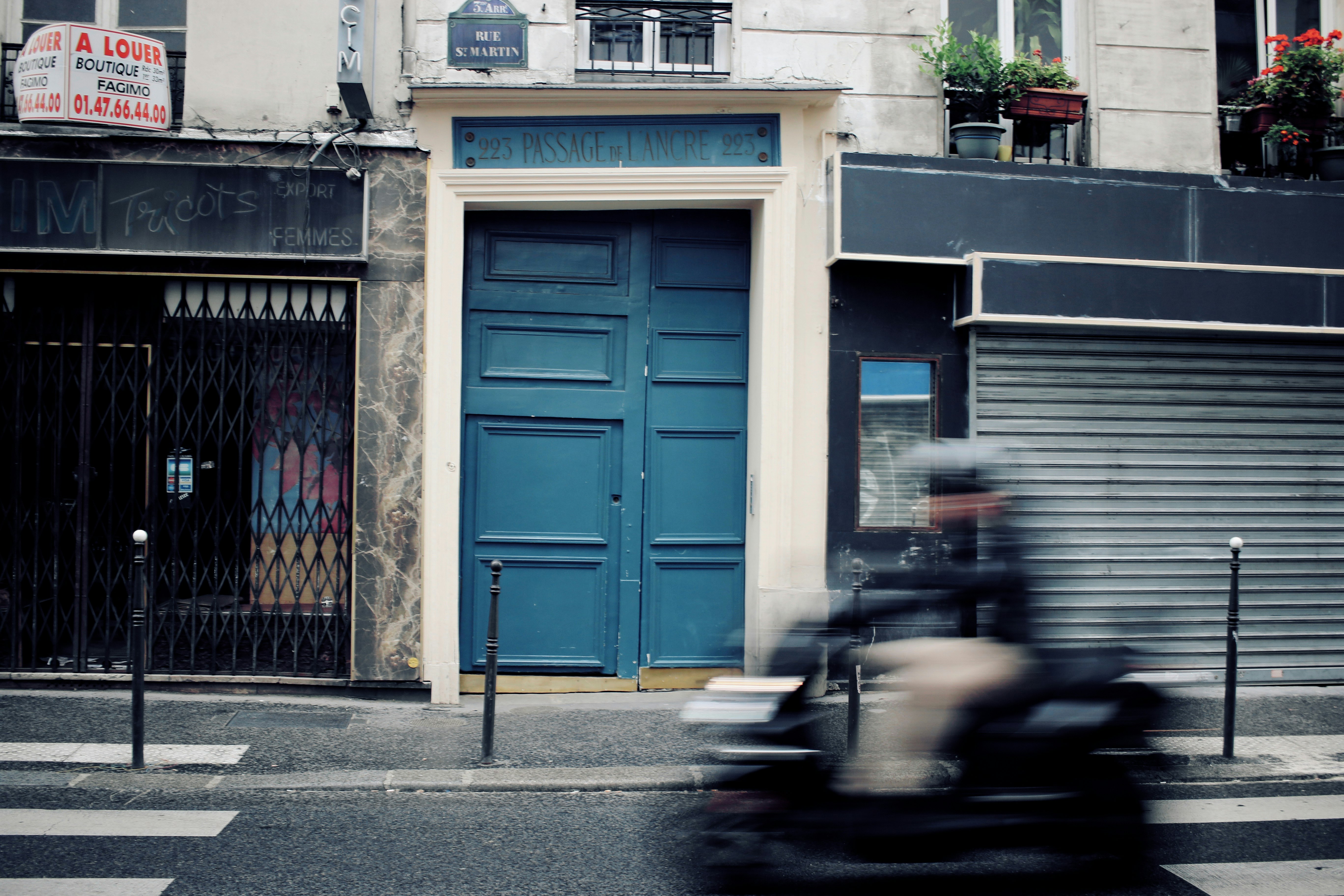 person passing gray and blue house